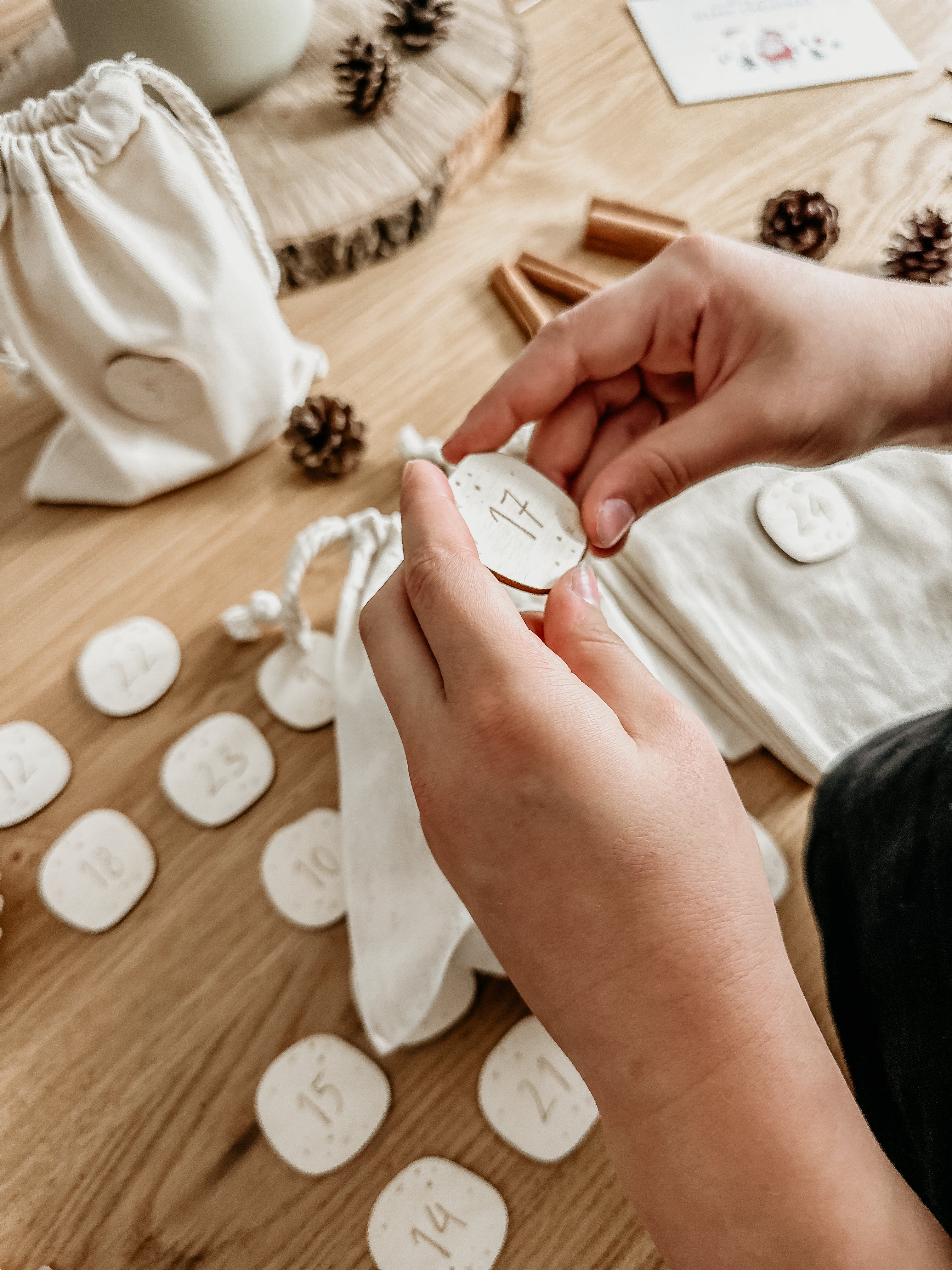 Mädchen hält Baumwollsäckchen mit Adventszahl 2 in den Händen. Adventskalenderzahlen | Zahlen | DIY Adventskalender | Advent | Weihnachtsdeko - 'Sternenstaub' - lyllevenn-store