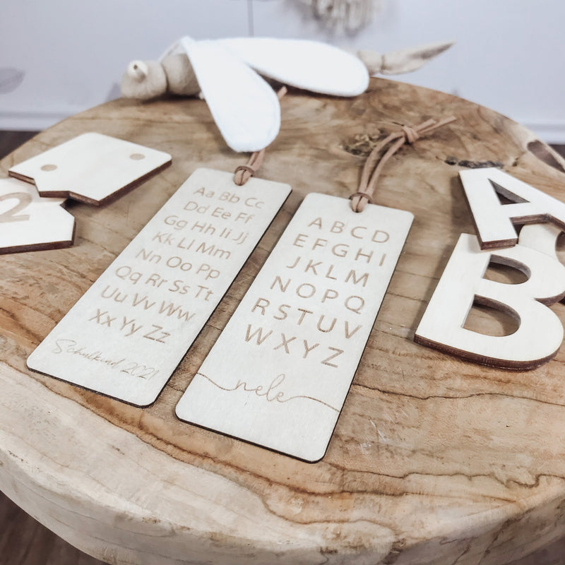 Elemente aus Holz Buchstaben und Buchzeichen auf Holzhocker liegend